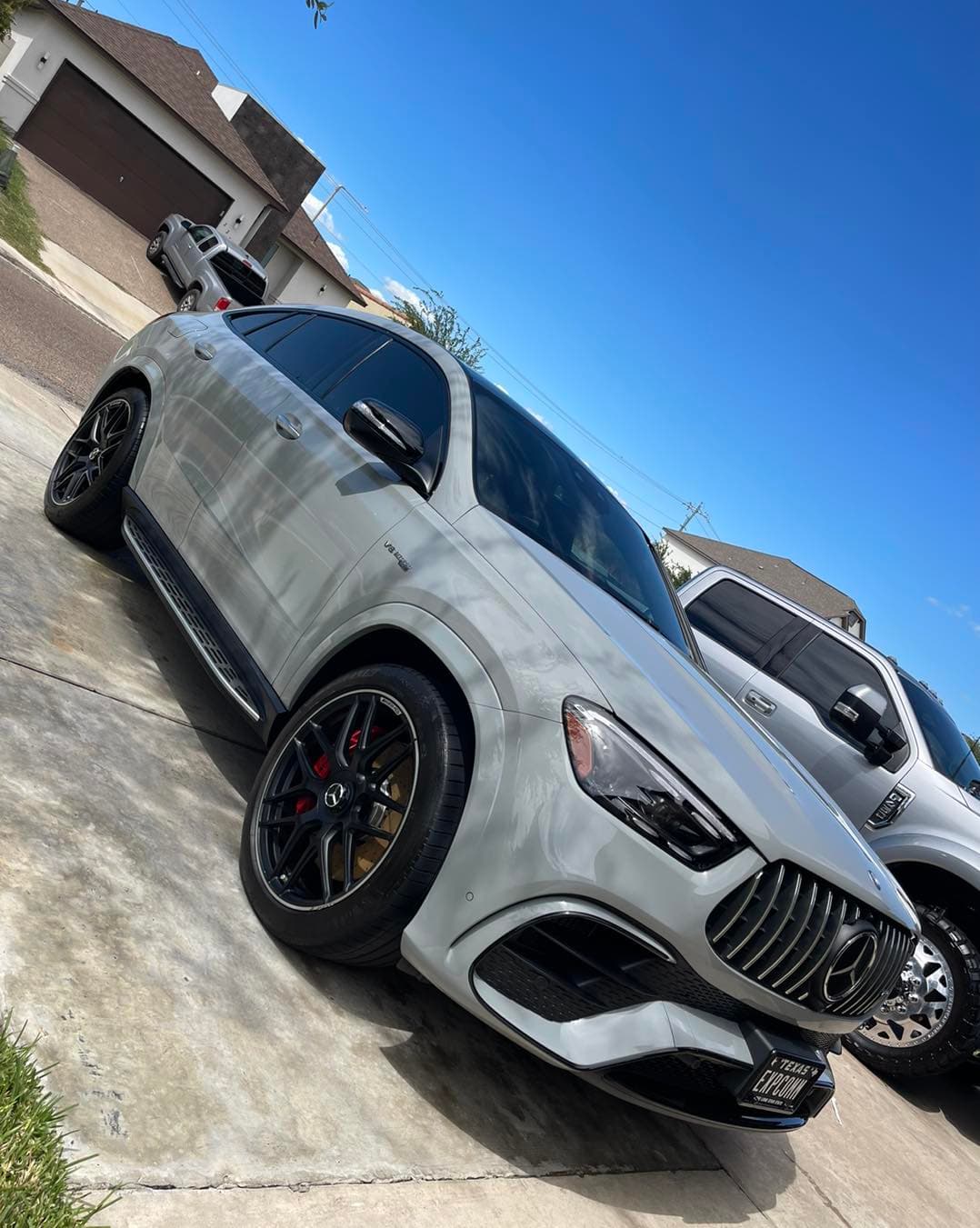 Grey Mercedes-AMG GLE SUV gleaming after a full exterior detail in a driveway under blue sky